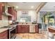 Well-lit kitchen featuring stainless steel appliances, stone counters, and a decorative backsplash at 21784 E Puesta Del Sol --, Queen Creek, AZ 85142