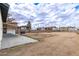 Expansive backyard presenting the home's exterior, a covered patio and a lot awaiting landscape design at 2256 W Ella St, Mesa, AZ 85201