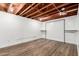 Spacious basement featuring an exposed ceiling, wood floors, and a custom clothing rack on the back wall at 2256 W Ella St, Mesa, AZ 85201