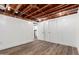 Finished basement area with wood-look flooring and white doors and walls beneath an exposed ceiling at 2256 W Ella St, Mesa, AZ 85201