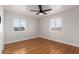 Cozy bedroom featuring two windows, hardwood floors and a modern ceiling fan at 2256 W Ella St, Mesa, AZ 85201