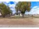 Charming home with mature trees and a chain-link fence at 2256 W Ella St, Mesa, AZ 85201