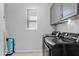 Well-lit laundry room featuring a modern washer and dryer, along with ample storage and neutral wall color at 2601 S Entwistle St, Gilbert, AZ 85295