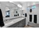 Main bathroom with double sinks, gray cabinets, a large mirror and a view of the main bedroom at 2601 S Entwistle St, Gilbert, AZ 85295