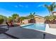 Sparkling pool area with outdoor seating and lush landscaping for a relaxing backyard oasis at 3044 E Trigger Way, Gilbert, AZ 85297