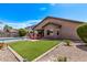 Lush backyard with a refreshing pool, fire pit, and vibrant green grass, ideal for relaxation and entertainment at 3044 E Trigger Way, Gilbert, AZ 85297