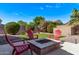 Cozy backyard fire pit with comfortable Adirondack chairs, perfect for outdoor entertaining and relaxation at 3044 E Trigger Way, Gilbert, AZ 85297