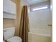 Well-maintained bathroom with shower and tub combo, storage cabinet, and window for natural light at 30718 N Coral Bean Dr, San Tan Valley, AZ 85143