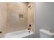 Close-up on a bathtub with tiled walls and niche with modern shower fixtures and toilet at 410 S 98Th Pl, Mesa, AZ 85208