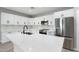 An open kitchen offers white cabinets, stainless appliances, and a center island at 410 S 98Th Pl, Mesa, AZ 85208