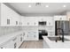 Stylish kitchen equipped with white cabinets, sleek appliances, and designer backsplash at 410 S 98Th Pl, Mesa, AZ 85208