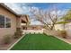 Landscaped backyard featuring artificial turf, BBQ and a covered patio at 412 W Lyle Ave, San Tan Valley, AZ 85140