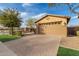 Charming front of the home featuring paver driveway, manicured landscape, and an attached two-car garage at 412 W Lyle Ave, San Tan Valley, AZ 85140