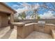 Outdoor kitchen with built-in BBQ, counter, and stucco base on a tiled patio at 412 W Lyle Ave, San Tan Valley, AZ 85140