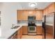 Well-lit kitchen features stainless appliances, mosaic backsplash and light wood cabinets at 453 N Alder Ct, Gilbert, AZ 85233