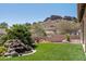 Backyard oasis with lush landscaping, a soothing waterfall feature, and scenic mountain views at 4846 S Rimrock Loop, Gold Canyon, AZ 85118