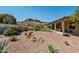 Landscaped backyard features gravel, green grass, outdoor seating, a charming yard art, and mountain views at 4846 S Rimrock Loop, Gold Canyon, AZ 85118