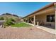 Expansive backyard with manicured lawn, decorative rock, and a covered patio for outdoor seating at 4846 S Rimrock Loop, Gold Canyon, AZ 85118