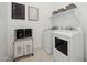 Organized laundry room with modern washer, dryer, shelving, and a practical laundry sorter for easy sorting at 505 E Aurora Dr, San Tan Valley, AZ 85140