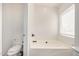 Bathroom with a soaking tub, toilet, and natural light from the window at 5313 W Jessica Ln Ln, Laveen, AZ 85339