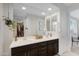 Bright bathroom featuring double sinks, sleek cabinetry, and a large mirror, with a walk-in closet nearby at 5431 S Canyon Rim --, Mesa, AZ 85212