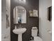 Stylish powder room with dark accent wall, modern fixtures, and decorative mirror at 5431 S Canyon Rim --, Mesa, AZ 85212