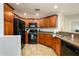 Well-lit kitchen featuring tile floors, granite counters, a gas range, and black appliances at 5450 E Deer Valley Dr # 3008, Phoenix, AZ 85054