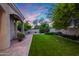 Manicured backyard featuring lush green lawn, gravel accents, shade trees, and a covered patio at 6132 E Yucca St, Scottsdale, AZ 85254