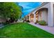 Expansive backyard featuring a lush lawn, sparkling pool, covered patio and elegant landscaping at 6132 E Yucca St, Scottsdale, AZ 85254