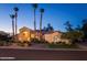 Elegant single-story home with a stucco exterior, mature palm trees, and a beautifully landscaped front yard at 6132 E Yucca St, Scottsdale, AZ 85254