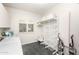 Bright laundry room with storage shelves, a window with plantation shutters, and a tiled floor at 6132 E Yucca St, Scottsdale, AZ 85254