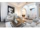 Spacious living room with hardwood floors, modern art, white pillars, and open archway to dining room at 6132 E Yucca St, Scottsdale, AZ 85254