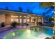 Beautiful outdoor pool at dusk, surrounded by lush landscaping and a covered patio area, perfect for entertaining at 6132 E Yucca St, Scottsdale, AZ 85254