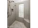 Modern tile shower with unique stone flooring and glass block window for natural light at 6132 E Yucca St, Scottsdale, AZ 85254