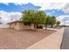 Charming single-story home with mature trees and a well-maintained yard on a sunny day at 641 N 61St Pl, Mesa, AZ 85205