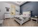 Charming bedroom featuring a white bed frame and contrasting blue accent wall at 7482 S Mccormick Way, Queen Creek, AZ 85142