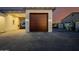 A close-up of a well-maintained garage with a wooden door and complementary stone accents and lighting at 7482 S Mccormick Way, Queen Creek, AZ 85142