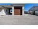 Stylish garage featuring a dark wood door, sconces, and a wide interlocking brick driveway at 7482 S Mccormick Way, Queen Creek, AZ 85142