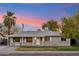 Charming single-story home featuring mature trees, a well-manicured lawn, and great curb appeal at 7729 E Catalina Dr, Scottsdale, AZ 85251