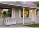 Close-up of the front porch with a decorative bench, white columns, and shuttered windows at 7729 E Catalina Dr, Scottsdale, AZ 85251