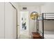 Hallway with wood-like floors and a view into a bedroom with closet space, round mirror and bunk beds at 7729 E Catalina Dr, Scottsdale, AZ 85251