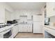 Bright kitchen featuring white cabinets, appliances, and light wood-look flooring at 7729 E Catalina Dr, Scottsdale, AZ 85251