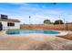 View of an in-ground pool with surrounding patio and privacy walls, next to grassy area and house at 8220 N 35Th Ave, Phoenix, AZ 85051