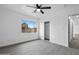 Bright bedroom with a ceiling fan, vinyl floors, closet, and natural light from a large window at 8220 N 35Th Ave, Phoenix, AZ 85051