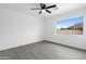 Minimalist bedroom featuring vinyl floors, ceiling fan, and a large window overlooking the yard at 8220 N 35Th Ave, Phoenix, AZ 85051