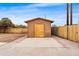 Backyard shed with boarded up door, surrounded by a concrete slab, block wall, and sparse landscaping at 8220 N 35Th Ave, Phoenix, AZ 85051