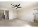 Spacious bedroom featuring neutral carpet, ceiling fan, and an ensuite bathroom with a glass shower at 8377 E Indian School Rd, Scottsdale, AZ 85251