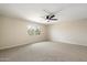 Bright bedroom with neutral carpet, ceiling fan, and a large window offering plenty of natural light at 8377 E Indian School Rd, Scottsdale, AZ 85251