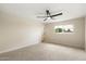 Bright bedroom with neutral carpet, ceiling fan, and a large window offering plenty of natural light at 8377 E Indian School Rd, Scottsdale, AZ 85251