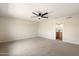 Expansive bedroom featuring neutral carpet, a ceiling fan, and an ensuite bathroom for convenience at 8377 E Indian School Rd, Scottsdale, AZ 85251